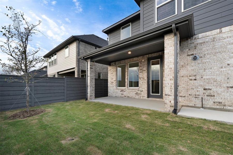 Back of house with a lawn and a patio area