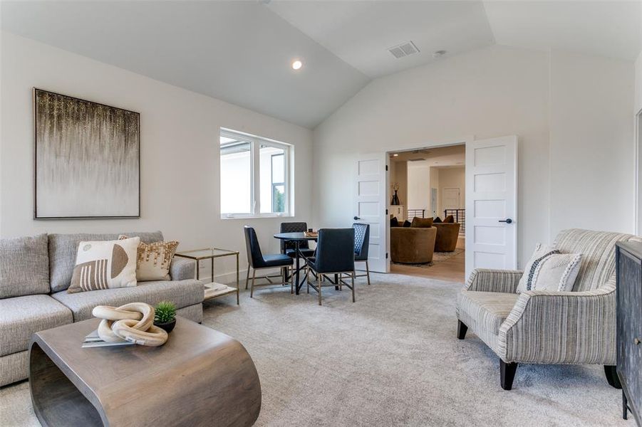 Living room featuring carpet and vaulted ceiling