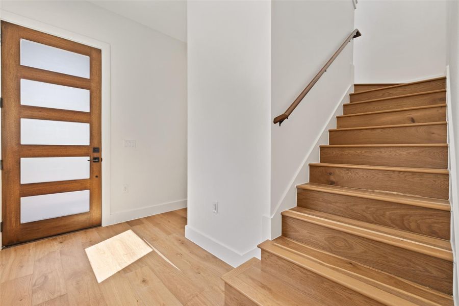Foyer entrance with stairway and light wood finished floors