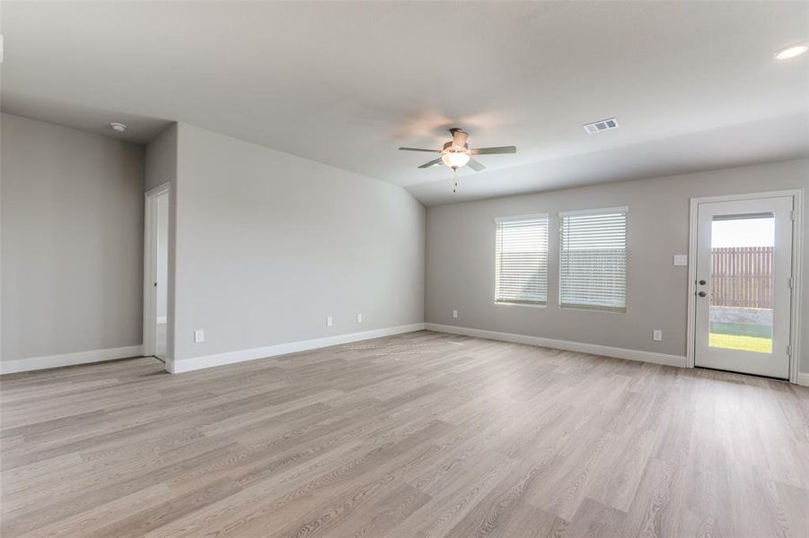 Unfurnished living room featuring light wood finished floors, healthy amount of natural light, and ceiling fan
