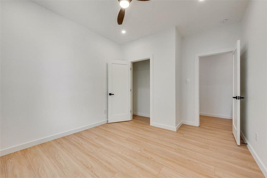 Unfurnished bedroom with ceiling fan, a closet, and light wood-type flooring