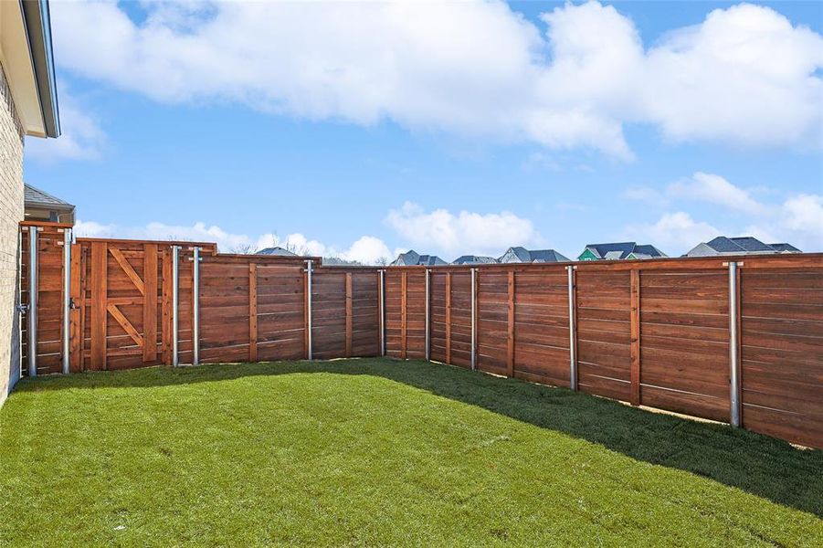 Fenced backyard featuring a gate