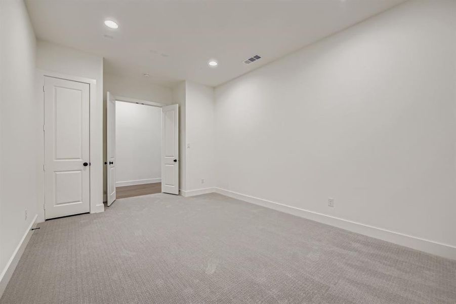 Below grade area with light carpet and recessed lighting