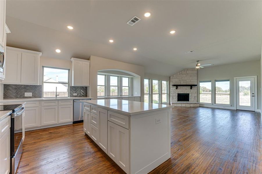 Kitchen with white cabinets, dark hardwood / wood-style floors, and plenty of natural light