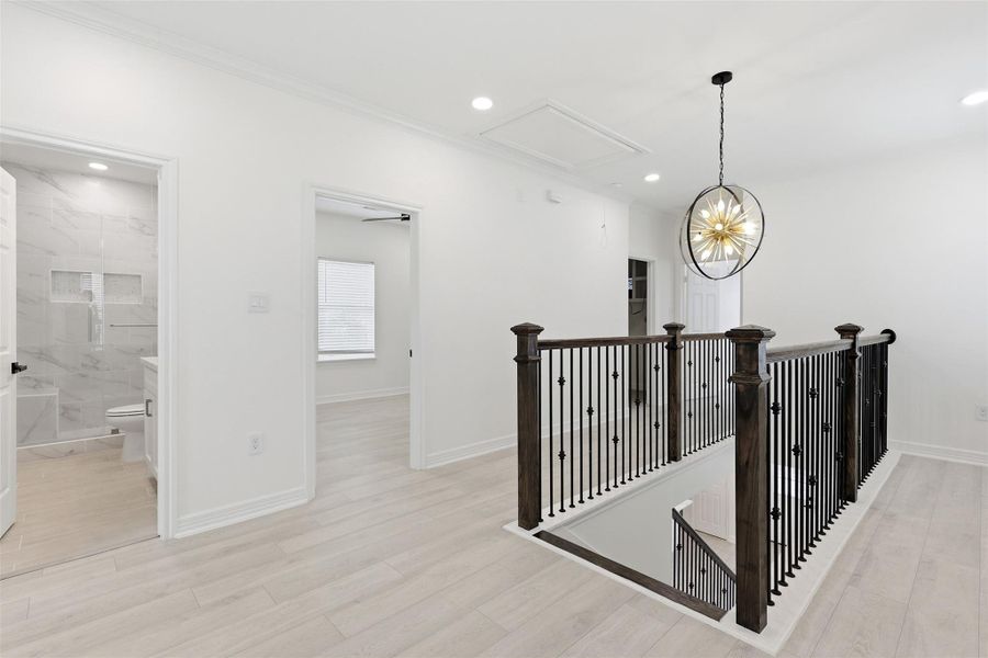 Second floor landing with elegant black iron railing, designer pendant light, and hallway access to all bedrooms.