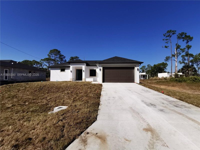 Front exterior of a new home in , Lehigh Acres, FL, highlighting curb appeal (Image 16).
