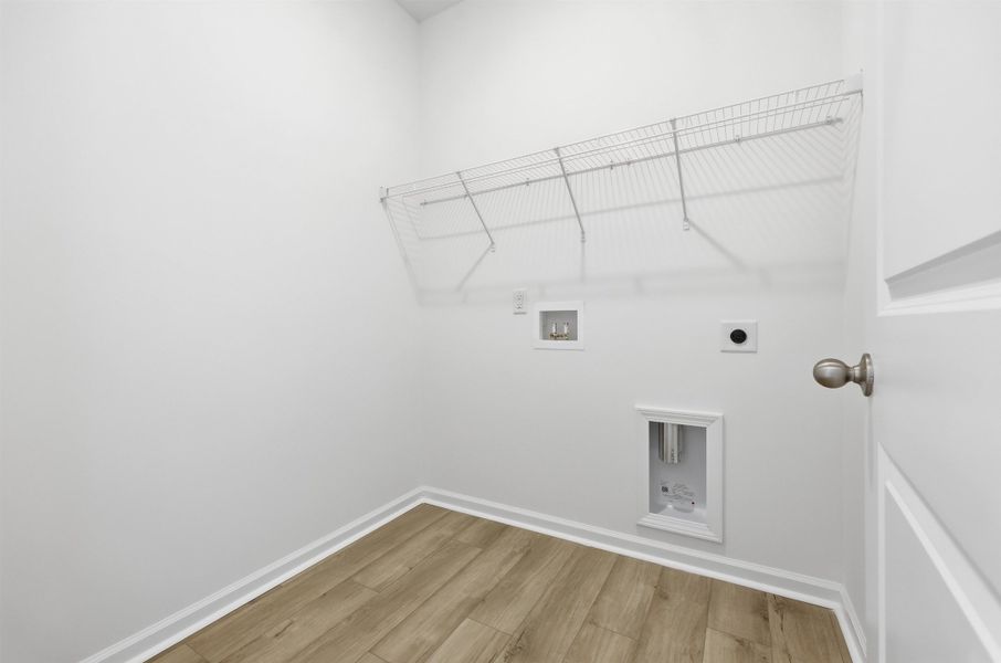 Washroom with light wood-type flooring, hookup for an electric dryer, and hookup for a washing machine Washroom with light wood-type flooring, hookup for an electric dryer, and hookup for a washing machine