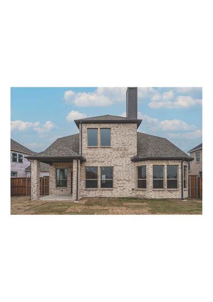 Back of house featuring a lawn and a patio