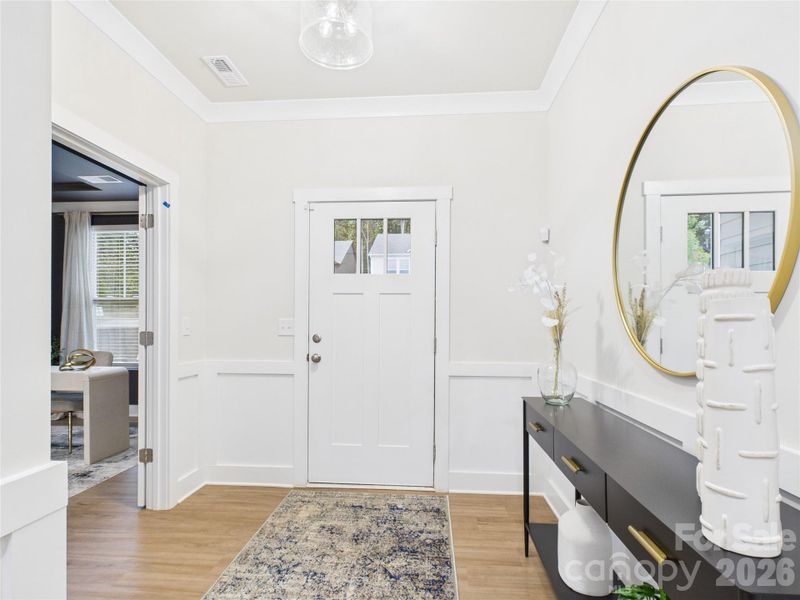 Foyer with crown molding and judge's panels