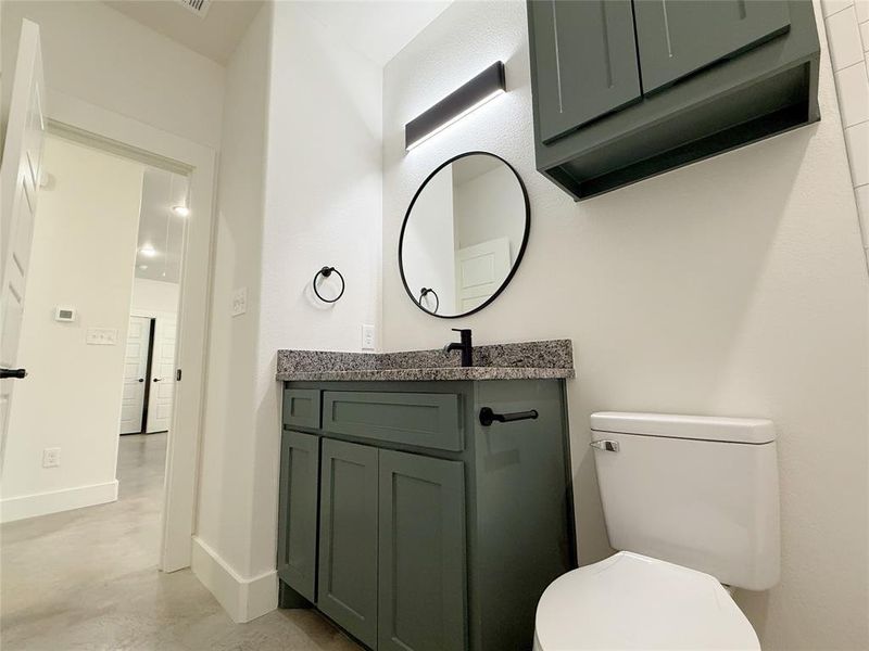 Bathroom with vanity, baseboards, concrete flooring, and toilet Bathroom with vanity, baseboards, concrete flooring, and toilet