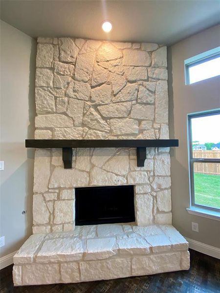 Stone GAS fireplace has raised hearth and cedar mantle. You can burn wood or gas logs.