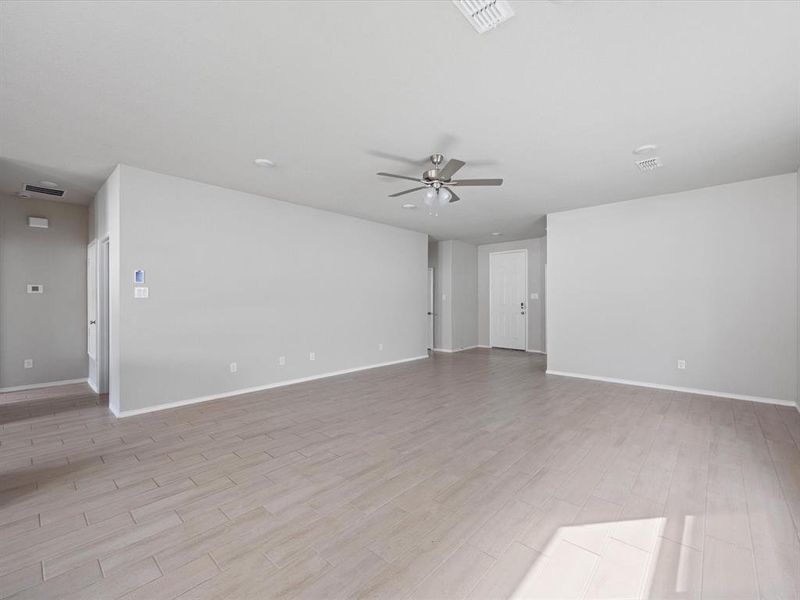 Unfurnished living room with light wood-style floors and ceiling fan Unfurnished living room with light wood-style floors and ceiling fan