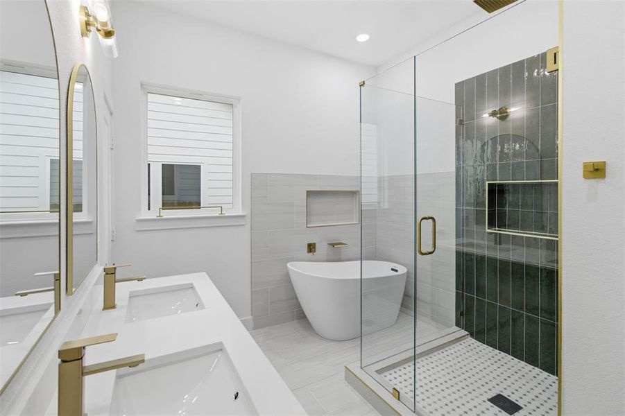 Bathroom featuring double vanity, a soaking tub, a shower stall, and recessed lighting
