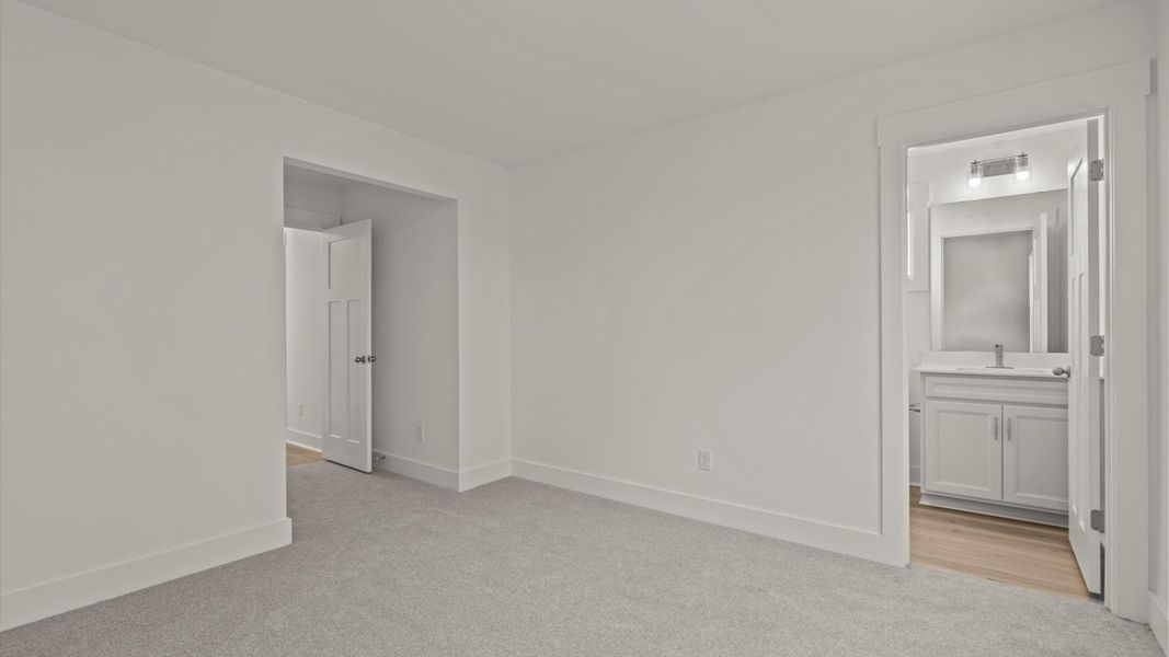 Notable secondary bedroom offering cozy carpeted flooring and a stylish walk-in closet