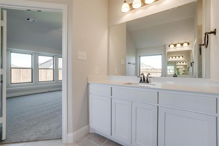 Bathroom with a wealth of natural light, tile patterned flooring, and vanity