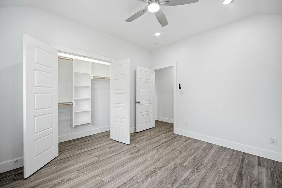 Room featuring light wood-finish flooring, white walls, and a contemporary ceiling fan Room featuring light wood-finish flooring, white walls, and a contemporary ceiling fan