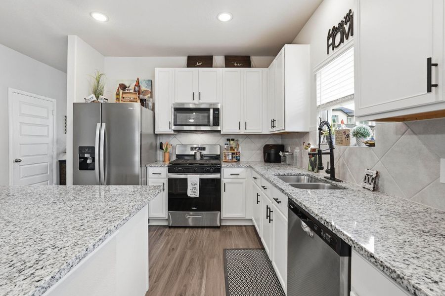 Kitchen features granite counters, gas cooktop and stainless  steel appliances