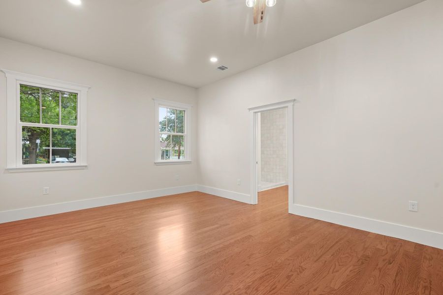 Hardwood flooring extends throughout this naturally illuminated primary bedroom, offering direct access to an adjacent bathroom. Hardwood flooring extends throughout this naturally illuminated primary bedroom, offering direct access to an adjacent bathroom.