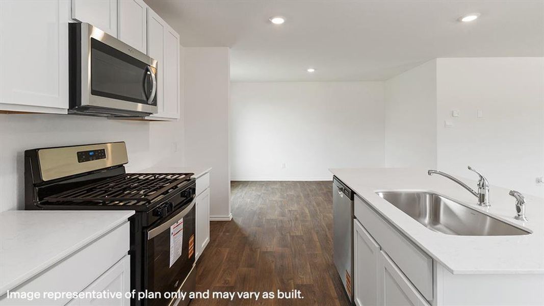 Kitchen featuring appliances with stainless steel finishes, white cabinets, light stone counters, dark wood-style flooring, and recessed lighting