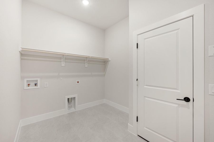 Laundry room with wall-mounted shelf, washer and dryer hookups, gas connection, and tile floor