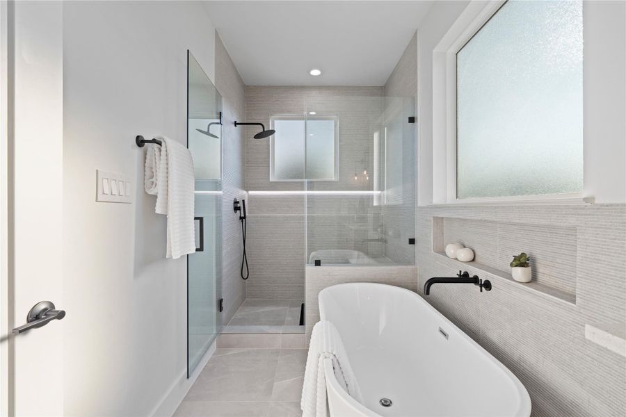 The ensuite boasts a freestanding tub paired with a massive frameless walk-in shower. This spa-inspired design combines luxury and functionality, offering a serene space to relax and refresh. Every detail invites indulgence, turning everyday routines into a pampering experience.