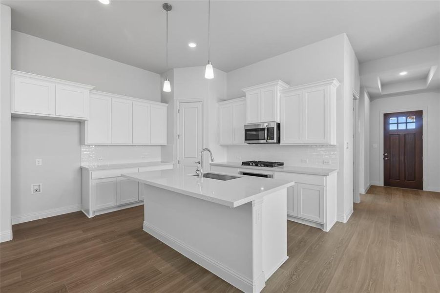 Kitchen with white cabinetry, dark wood finished floors, hanging light fixtures, recessed lighting, and backsplash