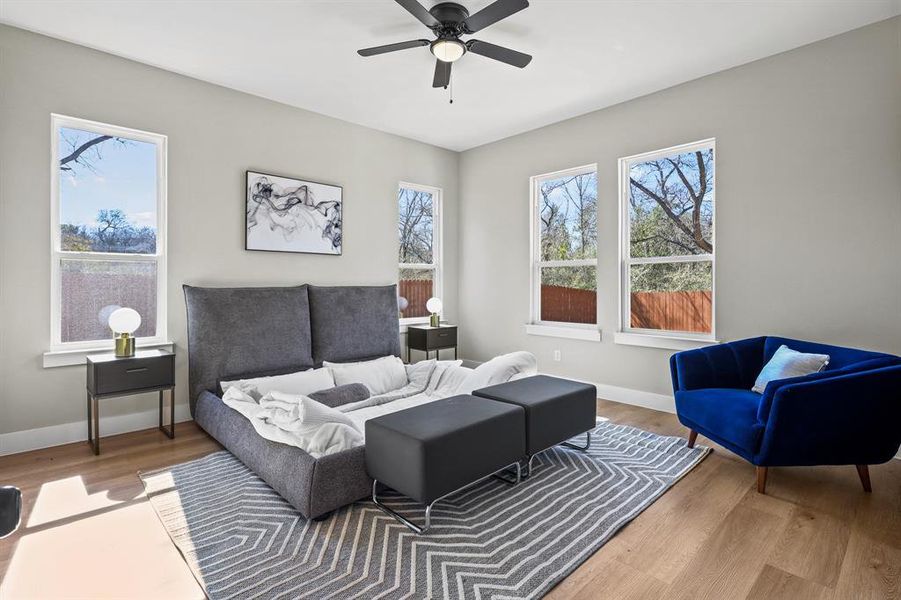 Living area featuring wood finished floors, a ceiling fan, and baseboards