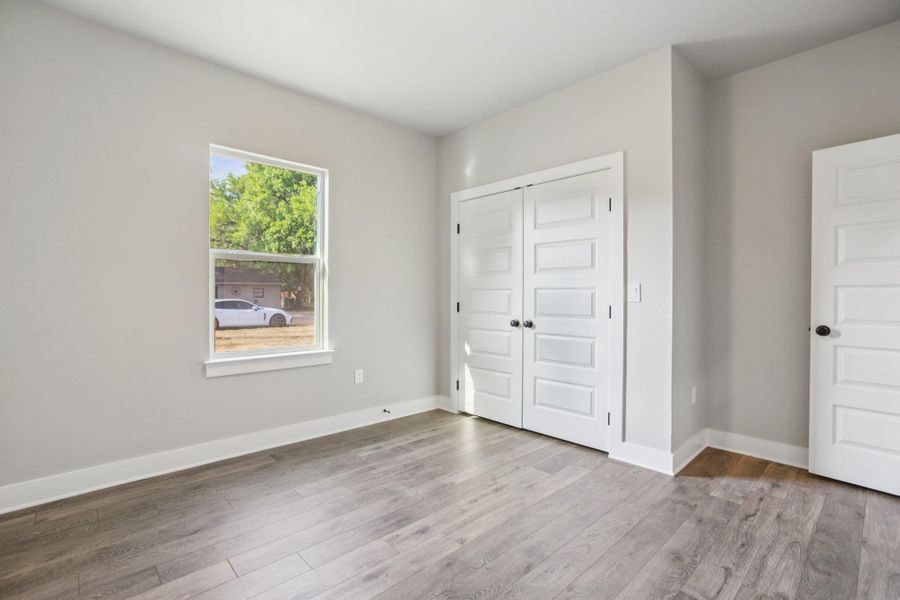 Unfurnished bedroom with light wood finished floors and a closet