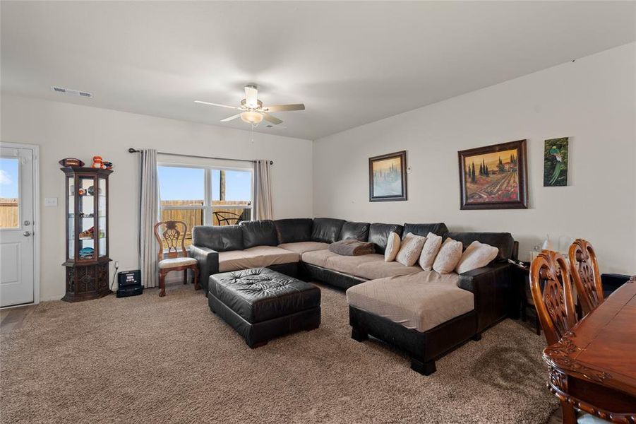 Living room featuring carpet flooring and ceiling fan
