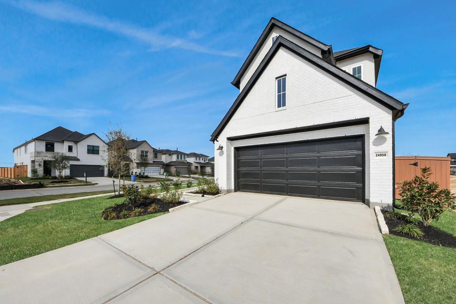 Front exterior of a new home in Elyson, Katy, TX, highlighting curb appeal (Image 23).