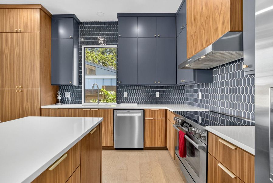 Kitchen with stainless steel appliances, modern cabinets, brown cabinets, and backsplash