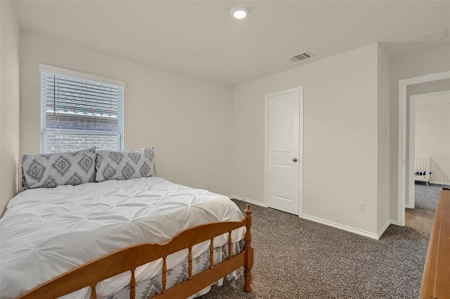 Carpeted bedroom featuring radiator heating unit