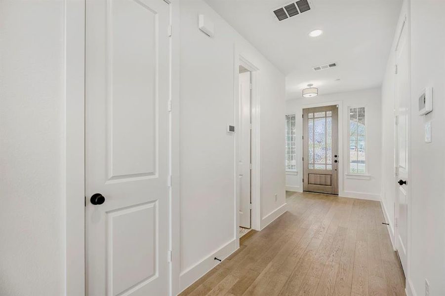 Entryway featuring wood-finish flooring, a decorative glass-paneled front door, and surrounding sidelight windows