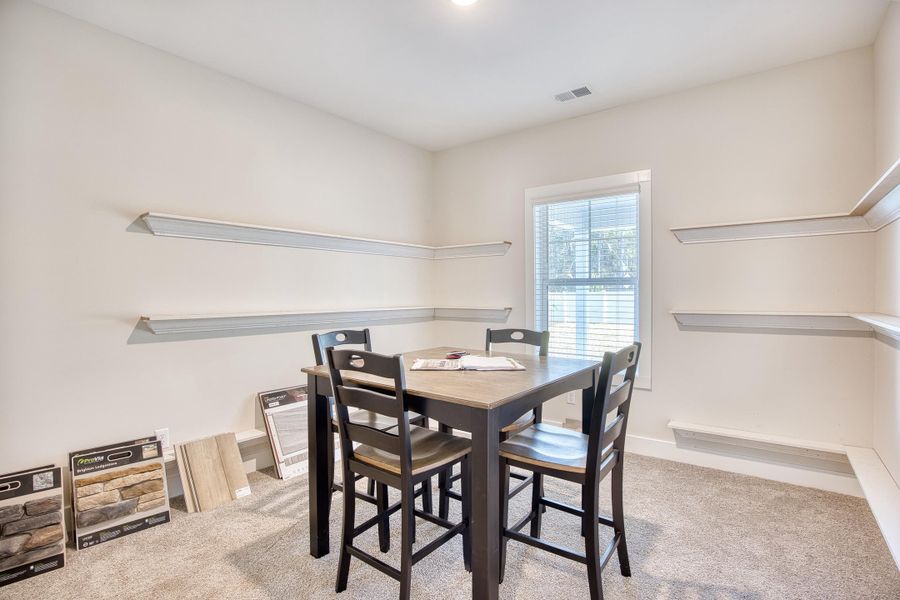 Dining room with light colored carpet