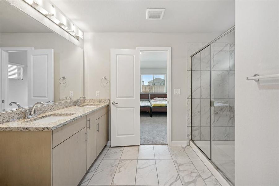 Bathroom with vanity and a shower with shower door