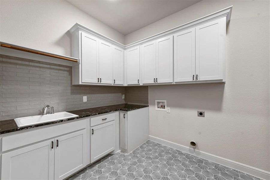 Washroom featuring cabinets, sink, hookup for a washing machine, hookup for an electric dryer, and light tile patterned flooring