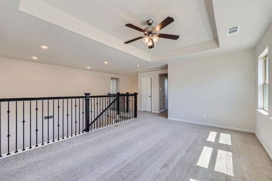 Game room featuring ceiling fan, light colored carpet, and a raised ceiling