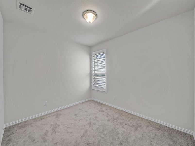 Empty room featuring light carpet