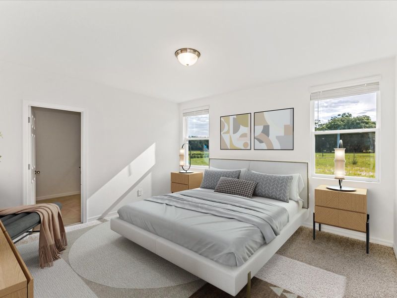 Staged primary bedroom in the Daphne floorplan at 2930 Sunstar Drive in The Reserve at Twin Lakes