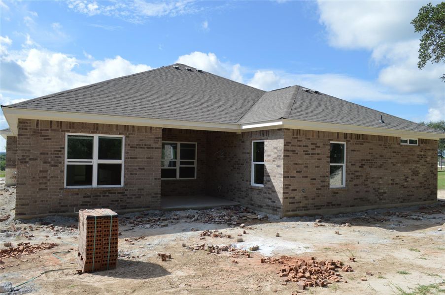 Rear view of house featuring brick siding, a shingled roof, and a patio area Rear view of house featuring brick siding, a shingled roof, and a patio area
