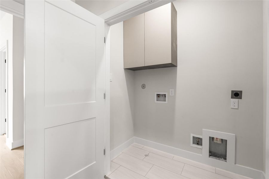 A dedicated utility room includes washer and dryer connections plus upper cabinetry for additional household storage.