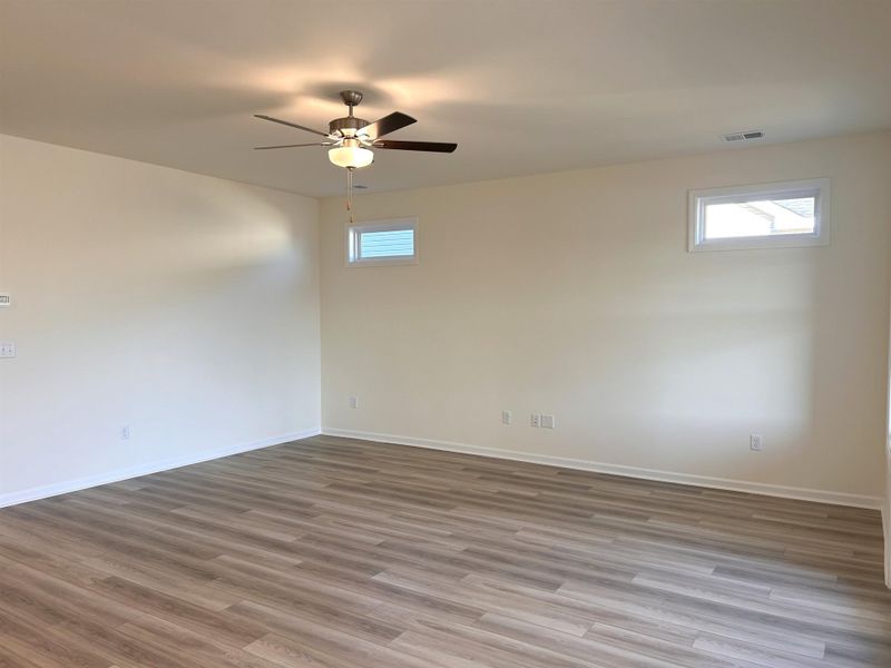 Unfurnished room with wood finished floors and a ceiling fan