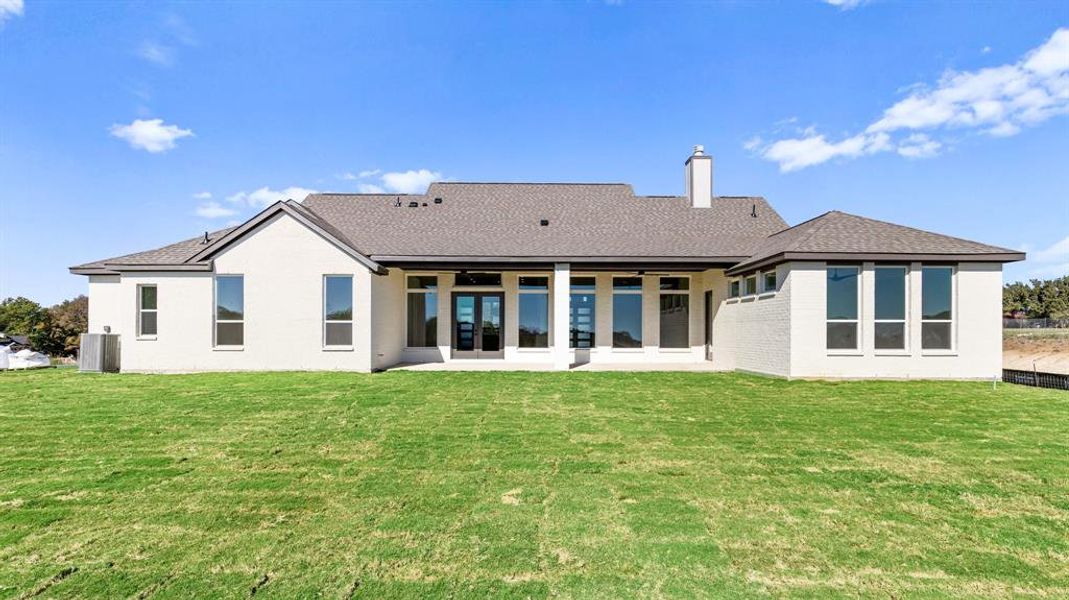 Rear view of house with a patio area and a lawn