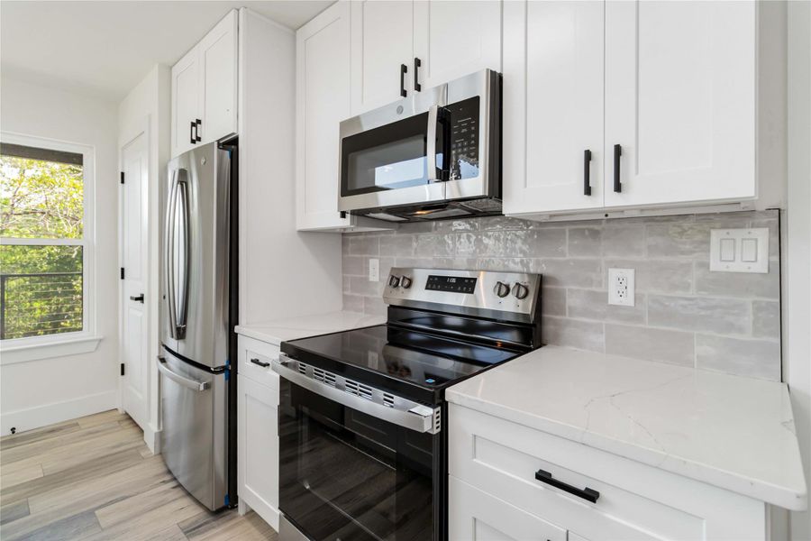 Sleek gray tile backsplash paired with stainless steel appliances for a modern, polished look. Sleek gray tile backsplash paired with stainless steel appliances for a modern, polished look.