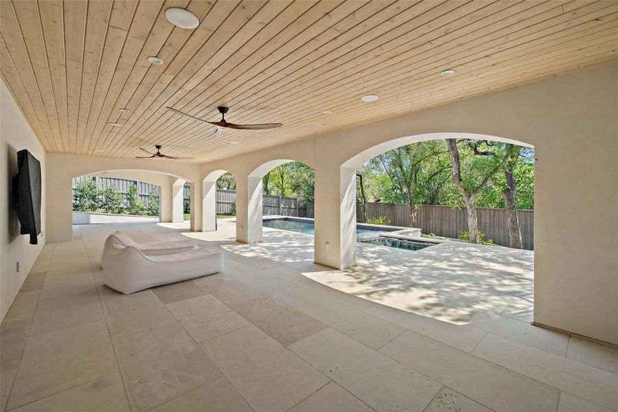 Fenced backyard featuring a hot tub, a patio area, and a ceiling fan Fenced backyard featuring a hot tub, a patio area, and a ceiling fan