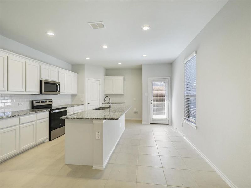 Kitchen featuring tasteful backsplash, a sink, appliances with stainless steel finishes, visible vents, and light stone countertops Kitchen featuring tasteful backsplash, a sink, appliances with stainless steel finishes, visible vents, and light stone countertops