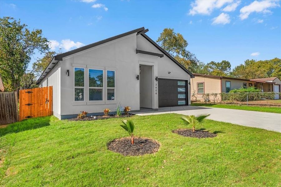 Modern home with driveway, a garage, a gate, and stucco siding