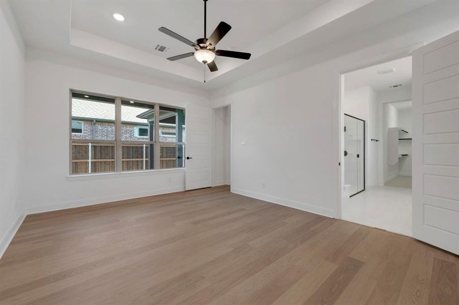 Empty room with a ceiling fan, light wood finished floors, and recessed lighting