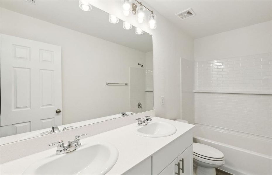 Upgraded secondary bathroom with dual vanity *real home pictured