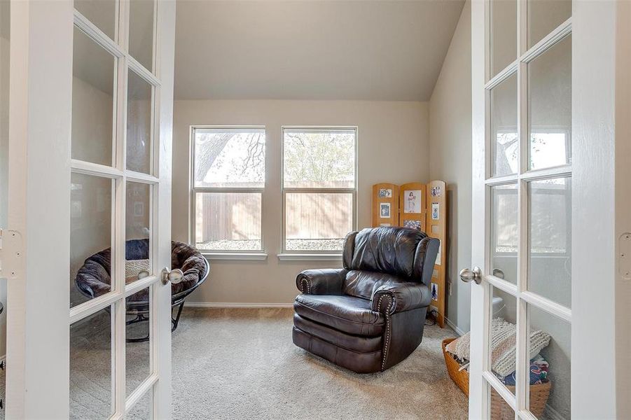 Sitting room featuring carpet, french doors, and vaulted ceiling